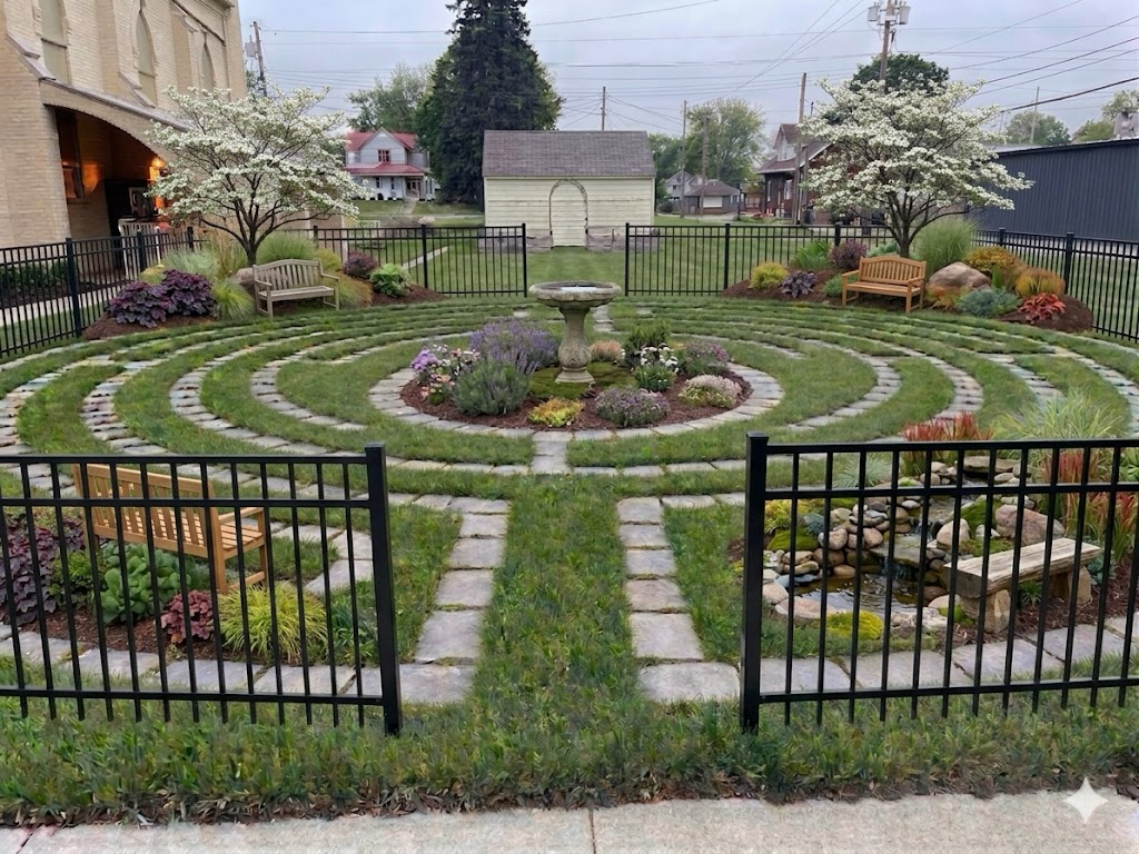 Artist rendering of a Finished Labyrinth, Grass, pavers for the walkway, black metal fence and trees/flowers
